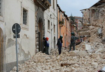 Hulpdiensten inspecteren beschadigde huizen in L’Aquila. (Foto Goldmund100/enpasedecentrale, Creative Commons)