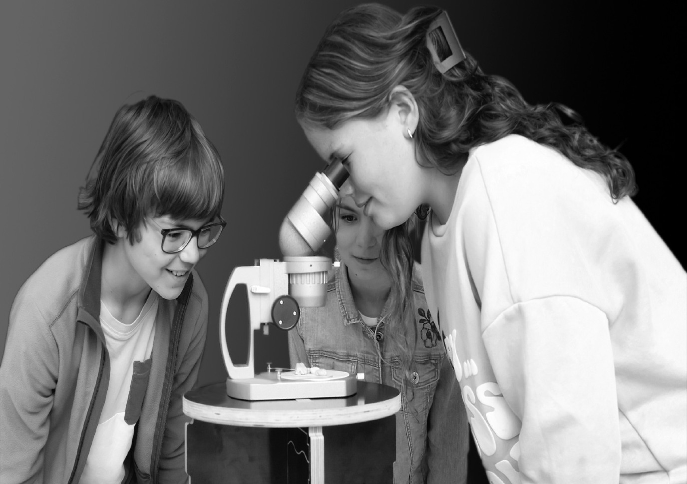 Foto van kinderen die een microscoop uittesten
