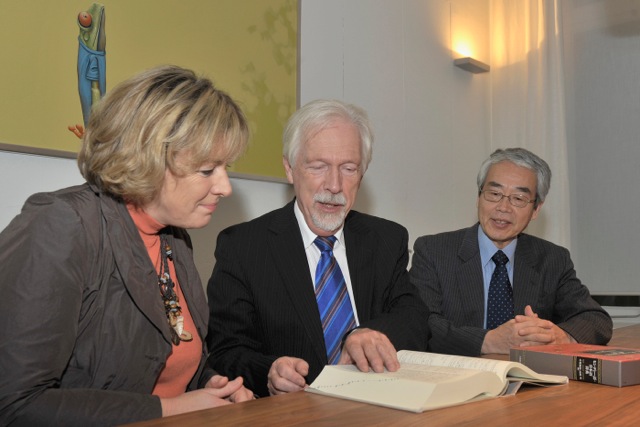 Prof. Poppema overhandigt het Japans-Hindi woordenboek aan Mevr. Nieboer in het bijzijn van Prof. Hirotsu.