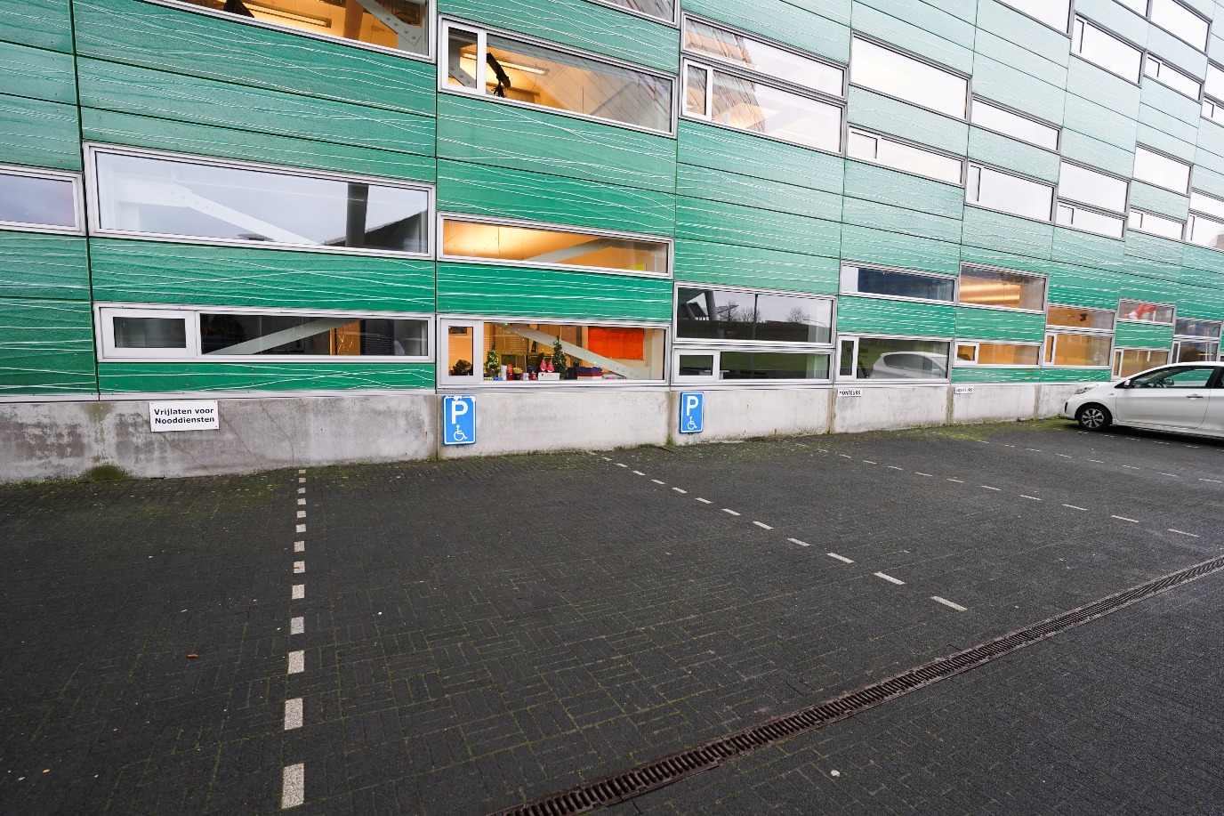 Parkeerplaatsen voor mindervaliden op locatie, rechts van de hoofdingang