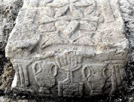 Een steen met daarop een menora, een zevenarmige joodse kandelaar, gevonden bij een archeologische opgraving bij het Meer van Tiberias. De steen is een overblijfsel van een synagoge uit de Tweede Tempelperiode, toen de scheiding tussen en christendom inzette. © FOTO EPA