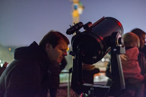 Een bezoeker bekijkt Jupiter door een telescoop | Foto: Joost van den Born