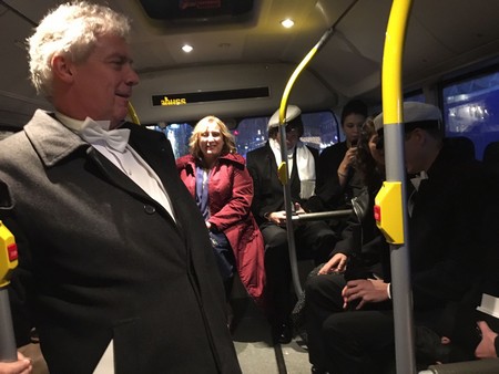 Kalter, rector Elmer Sterken (links) en andere gasten in de bus op weg naar het diner in de City Hall | Foto Maaike Borst, Dagblad van het Noorden