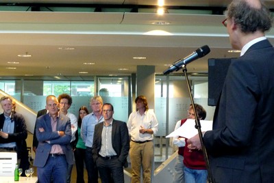 Peter van Haastert (blauw pak), met rechts naast hem Klaas Poelstra, wordt toegesproken door Jasper Knoester.