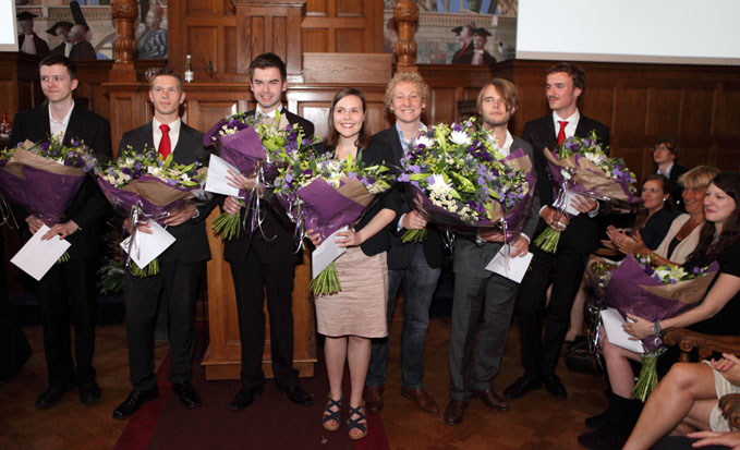 De winnaars van de GUF-100 prijzen zijn (vlnr): Lennart Baardman (Faculteit Economie en Bedrijfskunde), Rick Pleijhuis (Faculteit Medische Wetenschappen), Björn Hoops (Faculteit Rechtsgeleerdheid), Paula Prenzel (Faculteit Ruimtelijke Wetenschappen), Laurens Polgar (Faculteit Wiskunde en Natuurwetenschappen), Job de Grefte (Faculteit Wijsbegeerte), Casper Hesp (Faculteit Gedrags- en Maatschappijwetenschappen) en, zittend rechts, Laura Vollmer (Faculteit Godgeleerdheid en Godsdienstwetenschap). Niet op de foto: Anouk Baron (Faculteit der Letteren). Foto: Pjotr Wiesse