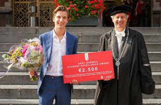 Thijmen Calis, winnaar van de Aart Bosman Student Excellence Award 2015, ontvangt felicitaties van rector magnificus prof. dr. Elmer Sterken. Foto: Gerhard Taatgen