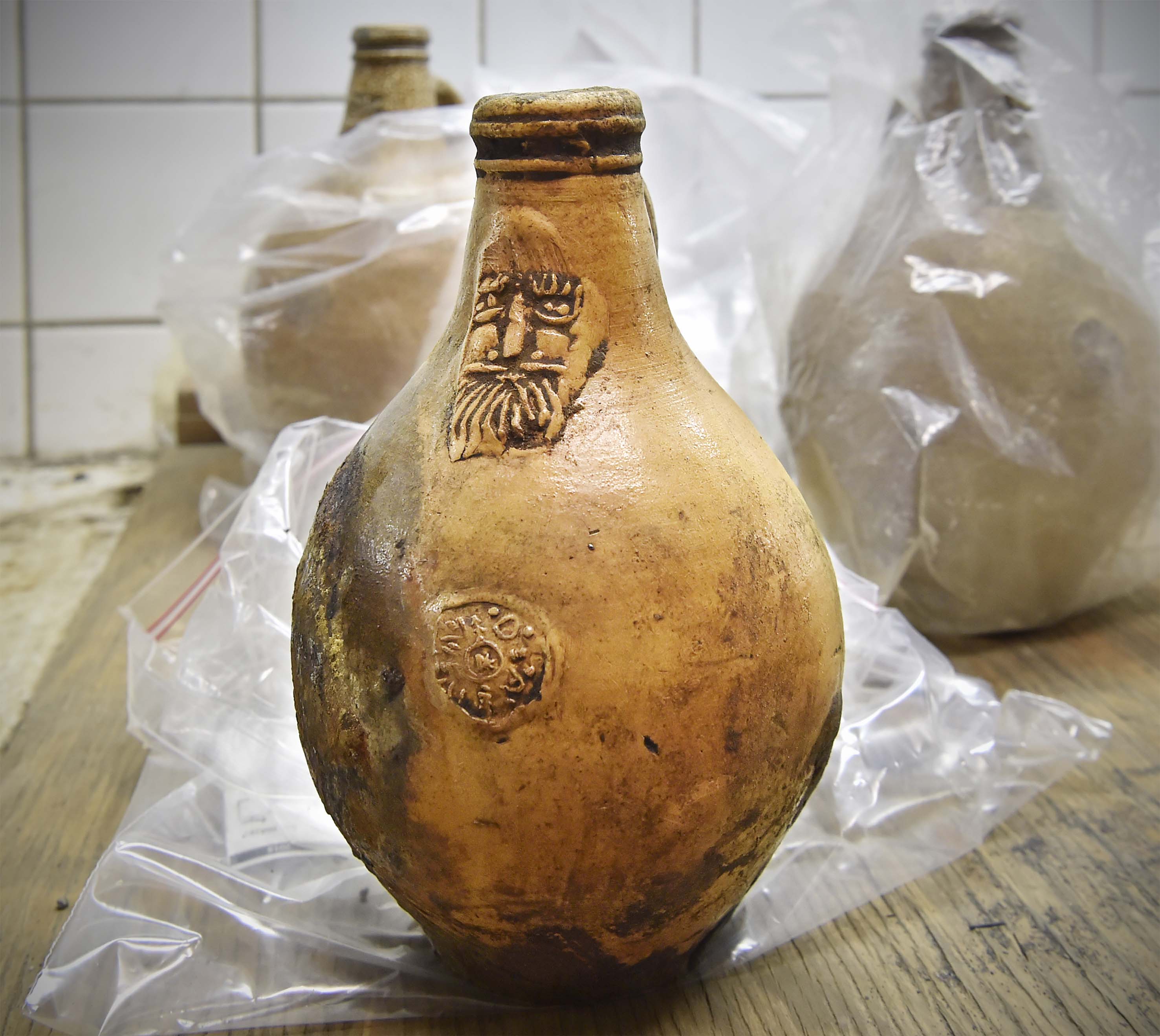 Een zogeheten baardmankruik uit Duitsland - met kurk! De vloeistof die nog in de fles zit wordt binnenkort onderzocht. Wat zal het zijn: water, bier, wijn? En hoe smaakt het nu?A Bartmann jug from Germany was also found, still corked! Researchers are working to identify the remaining liquid in the bottle. What could it be — water, beer, wine? And what would it taste like today?