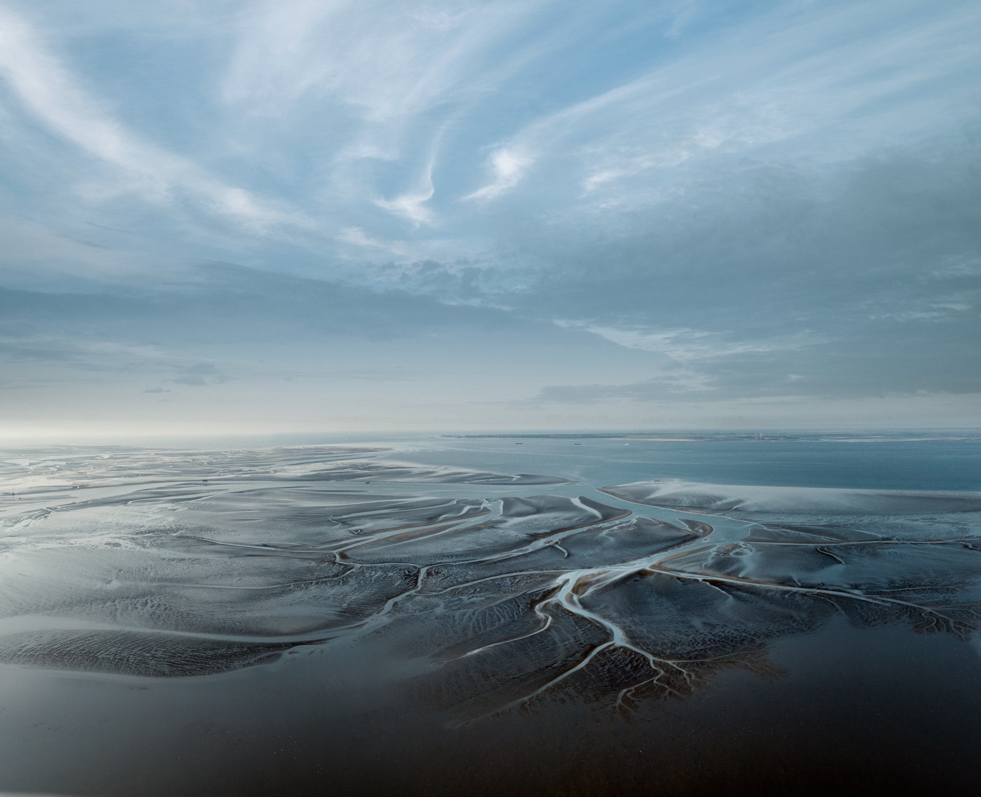 De Waddenzee bij Uithuizen. Via het vertakte geulenstelsel loopt het water uit de zee elk tij de wadplaten van de kust op. De RUG doet hier onderzoek naar onder meer kwelders, zeegras en bodemdieren.The Wadden Sea near Uithuizen. Through this branched channel system, the water from the sea is drawn up to the tidal flats along the coast during each tide. The UG is conducting research into salt marshes, eelgrass and bottom-dwellers.