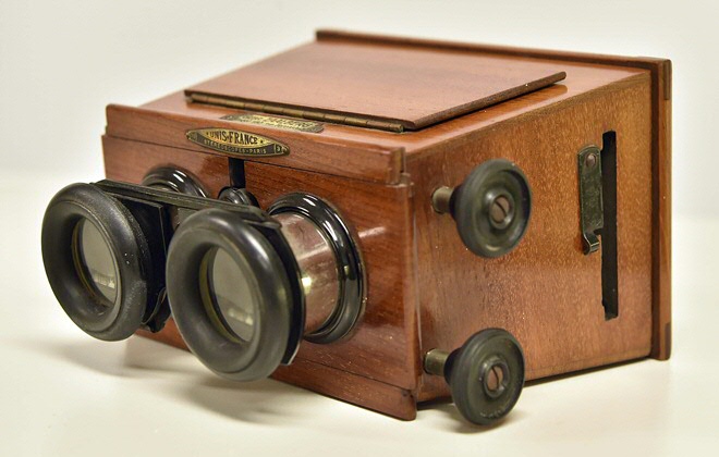 Replica van een stereoscoop, de voorloper van de VR-bril, midden 19e eeuw. Een plaat met een stereofoto wordt voor de lenzen geschoven waardoor er één afbeelding ontstaat met dieptewerking.Replica of a stereoscope, the precursor of VR glasses, mid-19th century. A slide with a stereo photo is placed in front of the lenses, creating one image with a depth effect.