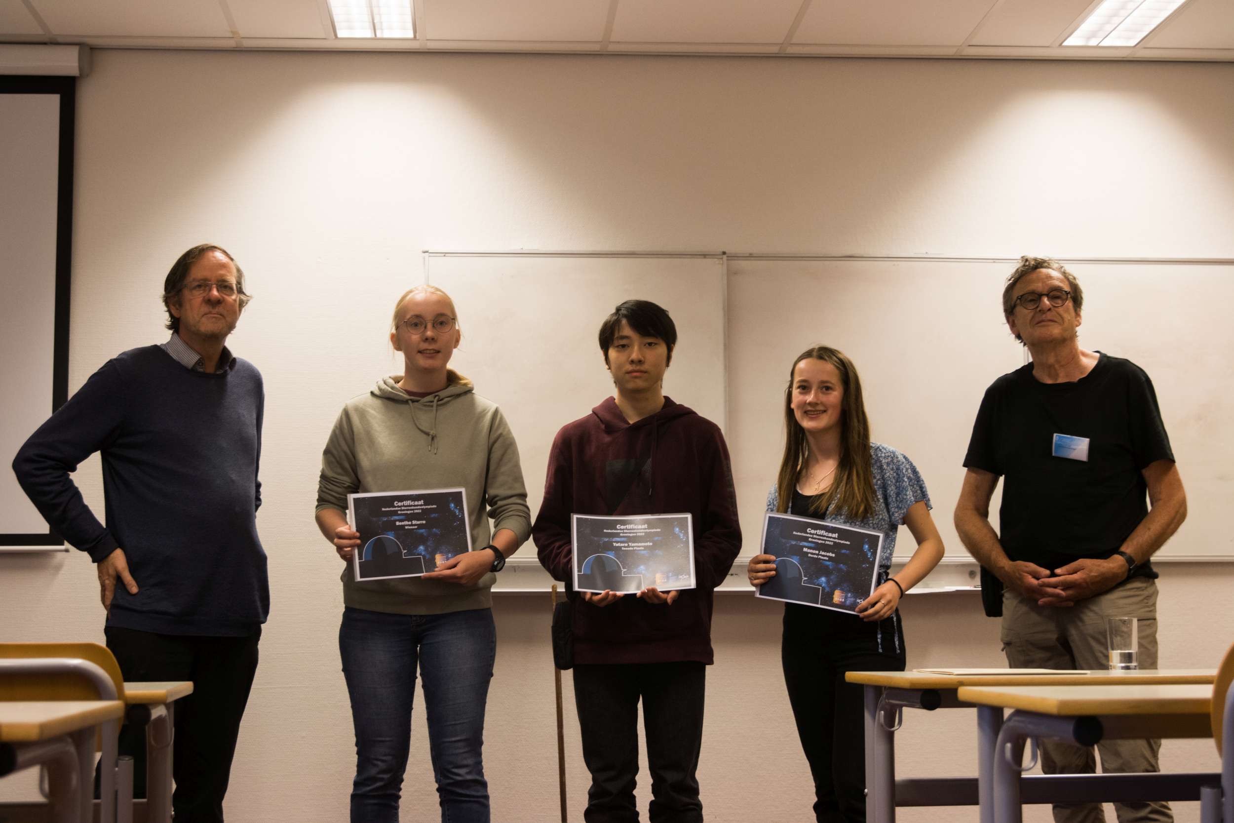 V.l.n.r.: Reynier Peletier (hoogleraar Sterrenkunde, organisator Olympiade). Benthe Sturre (winnaar), Yutaro Yamamoto (2e prijs). Manon Jacobs (3e prijs), Paul Feldbrugge (organisator Olympiade).