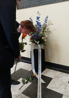 Studentenvertegenwoordigers leggen bloemen bij het monument voor omgekomen medewerkers