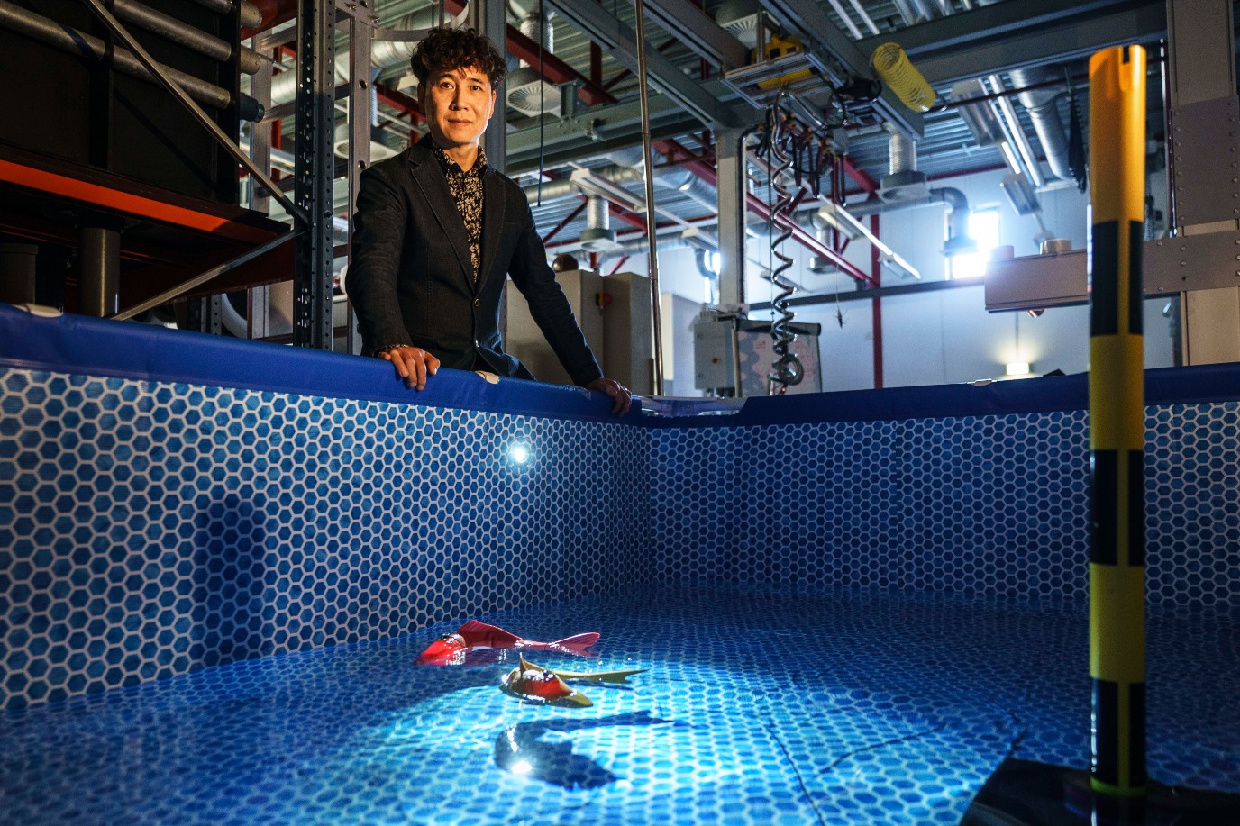 Ming Cao bij het bad met robotvissen