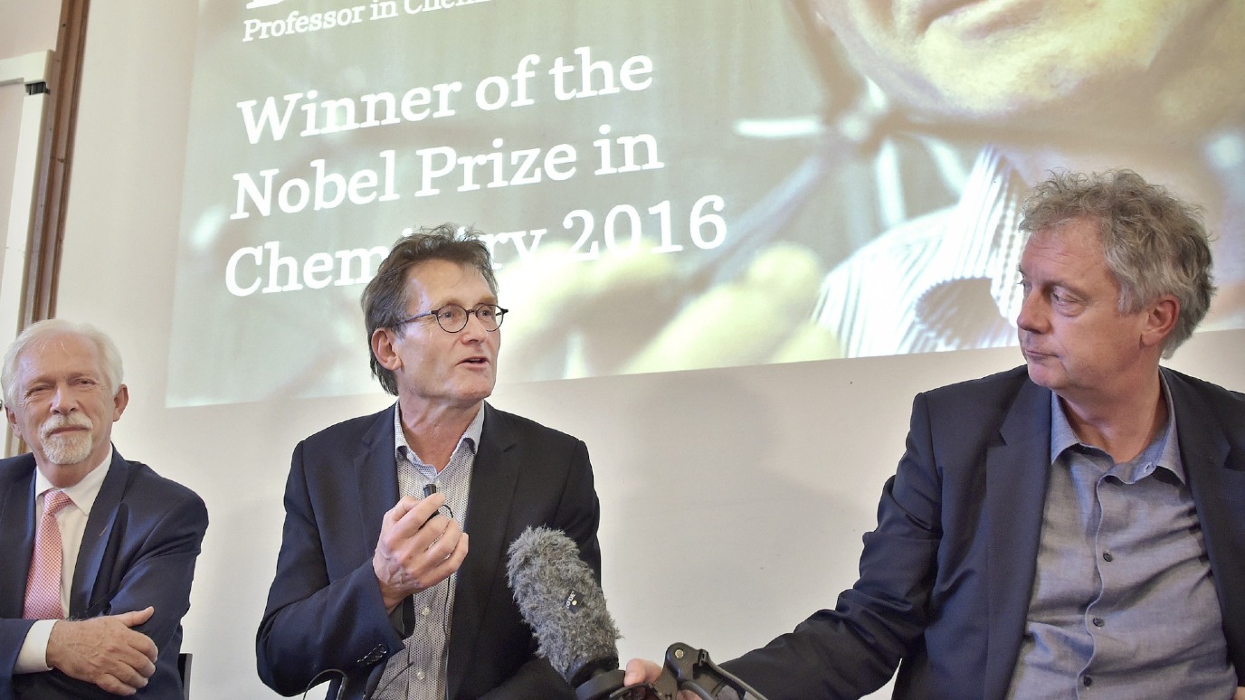 Feringa (midden) spreekt samen met Sybrand Poppema (links, destijds voorzitter van het College van Bestuur) en Elmer Sterken (rechts, destijds rector magnificus) de pers toe. Foto: Elmer Spaargaren
