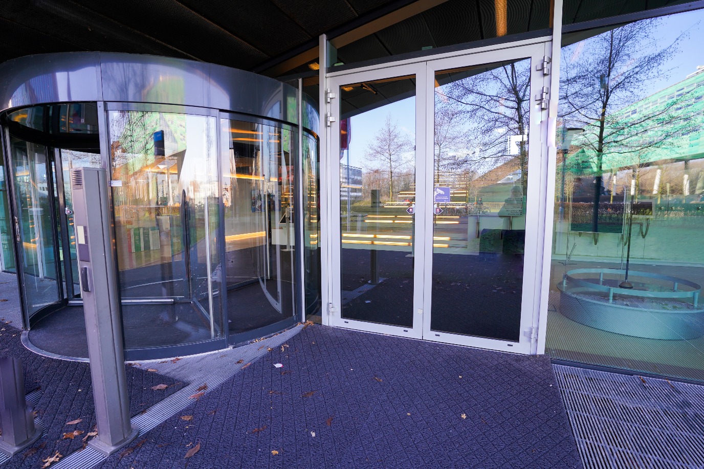 Doors next to revolving doors, receptionist can open doors from above