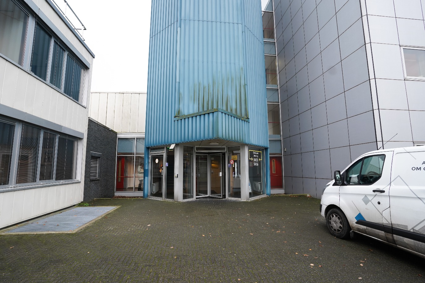 Side entrance to the building, revolving door and left door with push button