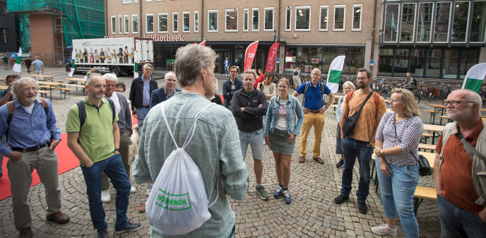 Beno Hofman spreekt alumni toe bij de start van de wandeling