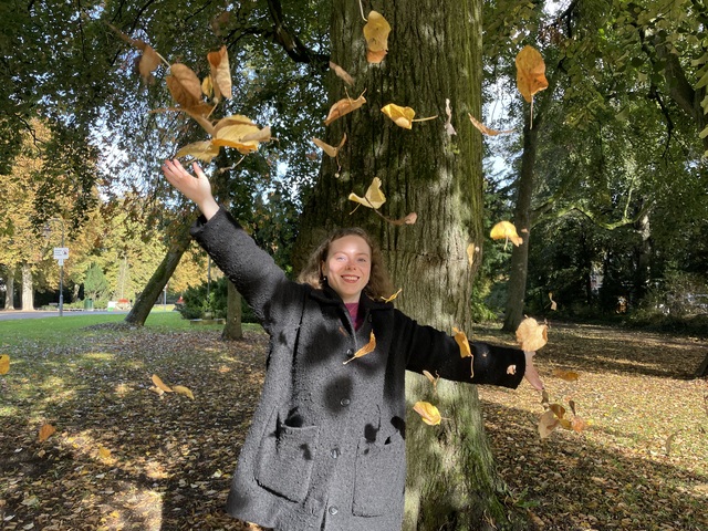 Hylke happily throwing leaves in the air.