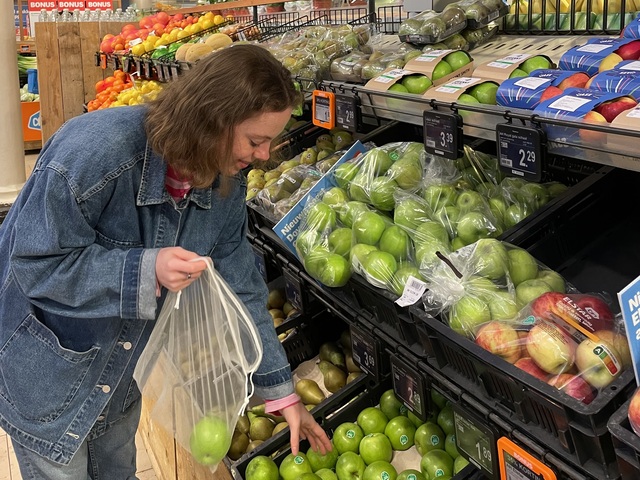 Hylke using reusable, sustainable bags instead of plastic bags when buying apples at the supermarket.