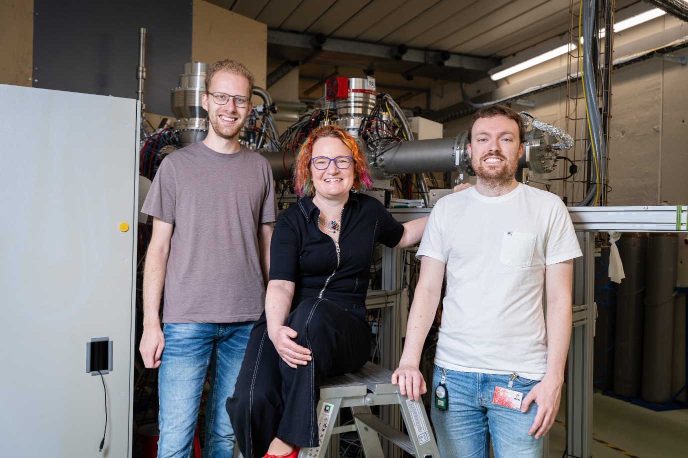 Julia Even met promovendus Jasper Westbroek (links) en postdoc Adam McCarter (rechts) voor de analyse-instrumenten die de massa en het verval van de gevormde zware kernen meten.