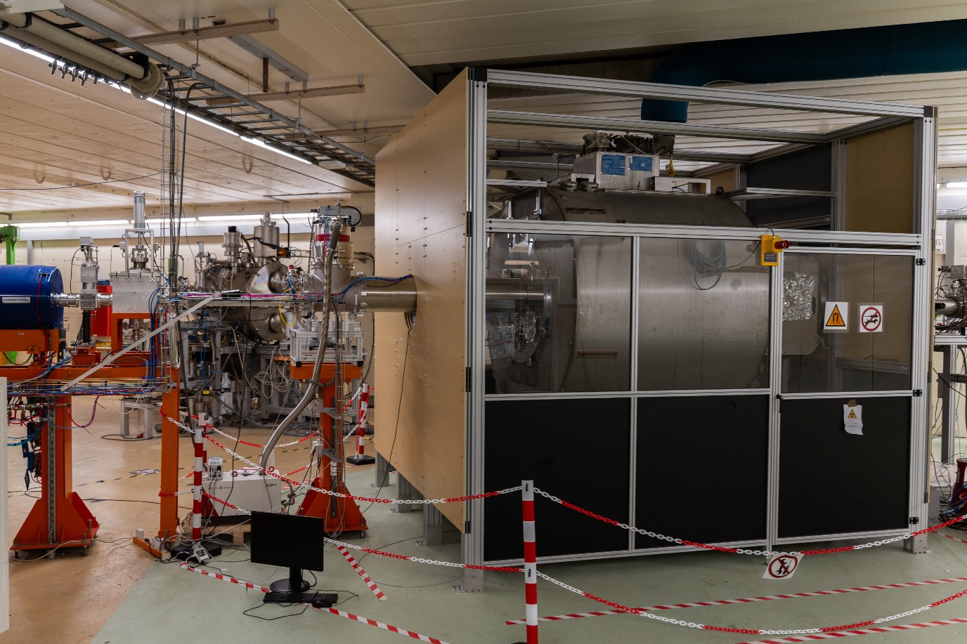 Het eerste deel van het NEXT experiment, waar versnelde atoomkernen botsen met een &lsquo;target&rsquo; van folie in de grote magneet (de metalen cilinder) waar zware kernen ontstaan, die vervolgens door een magnetisch veld naar het analytische instrumenten aan de rechterkant worden getransporteerd.