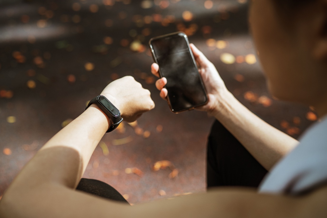 iemand met een fitnesstracker bekijkt de resultaten op een telefoon