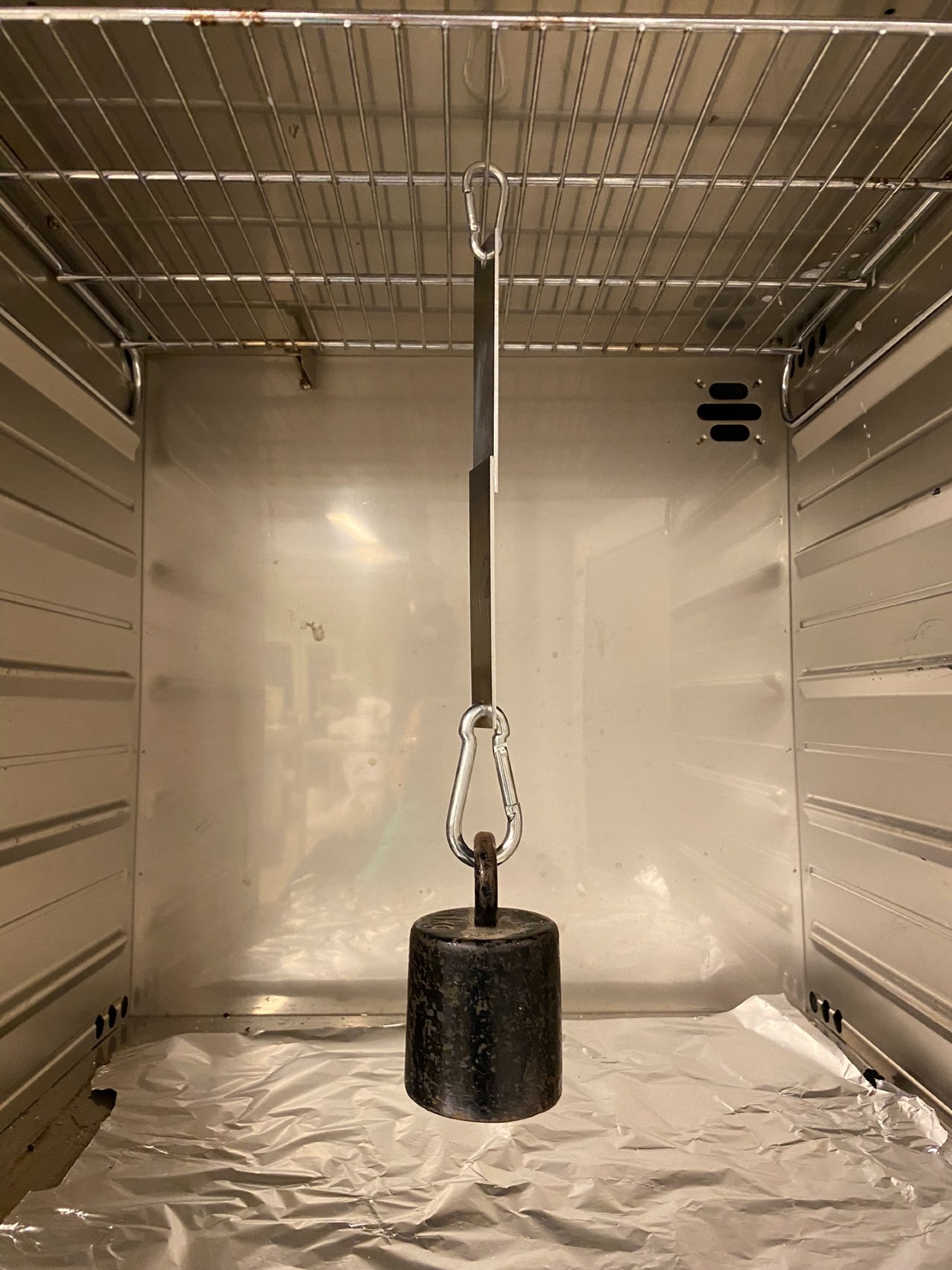 Met het gewicht in de oven testen de onderzoekers of de lijm ook blijft houden bij (iets) hogere temperaturen. Uiteindelijk moet de lijm pas weer loskomen bij blootstelling aan, bijvoorbeeld, een combinatie van UV-licht en hoge temperatuur.