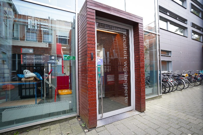 Rolstoelvriendelijke hoofdingang van het gebouw, bereikbaar via de steeg aan de rechterkant van het gebouw