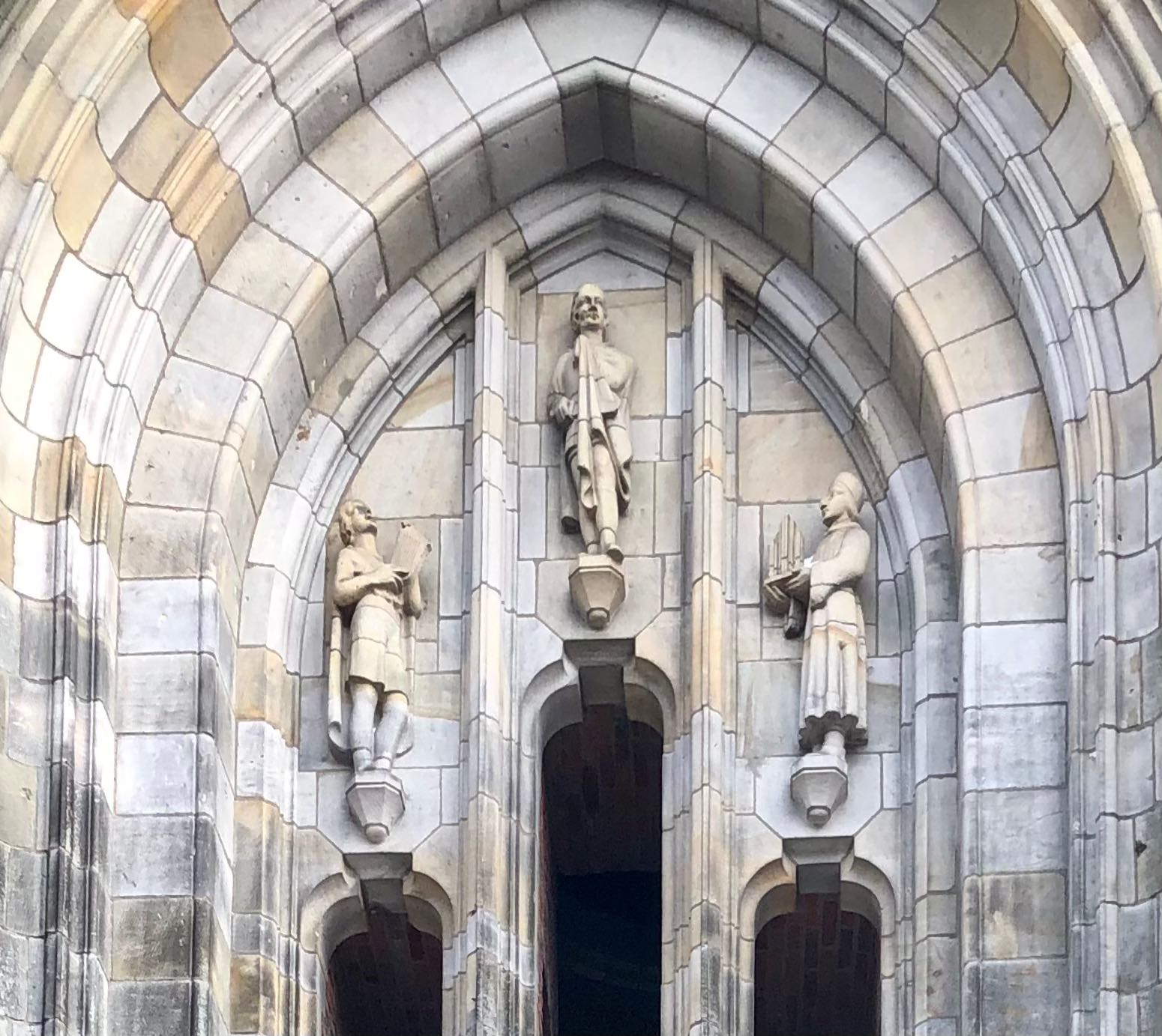 From left to right: Bernlef (with lyre), St Martin (with cape) and Agricola (with organ) above the western portal of the Martini Tower in Groningen (Willem Valk, 1940, sandstone)