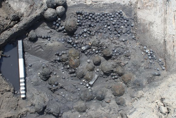 Munitievoorraad in het achterschip, bestaande uit honderden musket- en kanonskogelsMunitions supply in the stern, consisting of hundreds of musket and cannonballs.