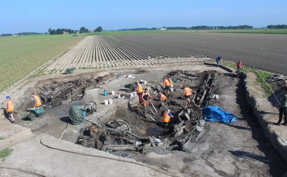 Overzichtsfoto van de opgravingsput met links het stuurboordgedeelte van de bodem en rechts de omgevallen bakboordzijde