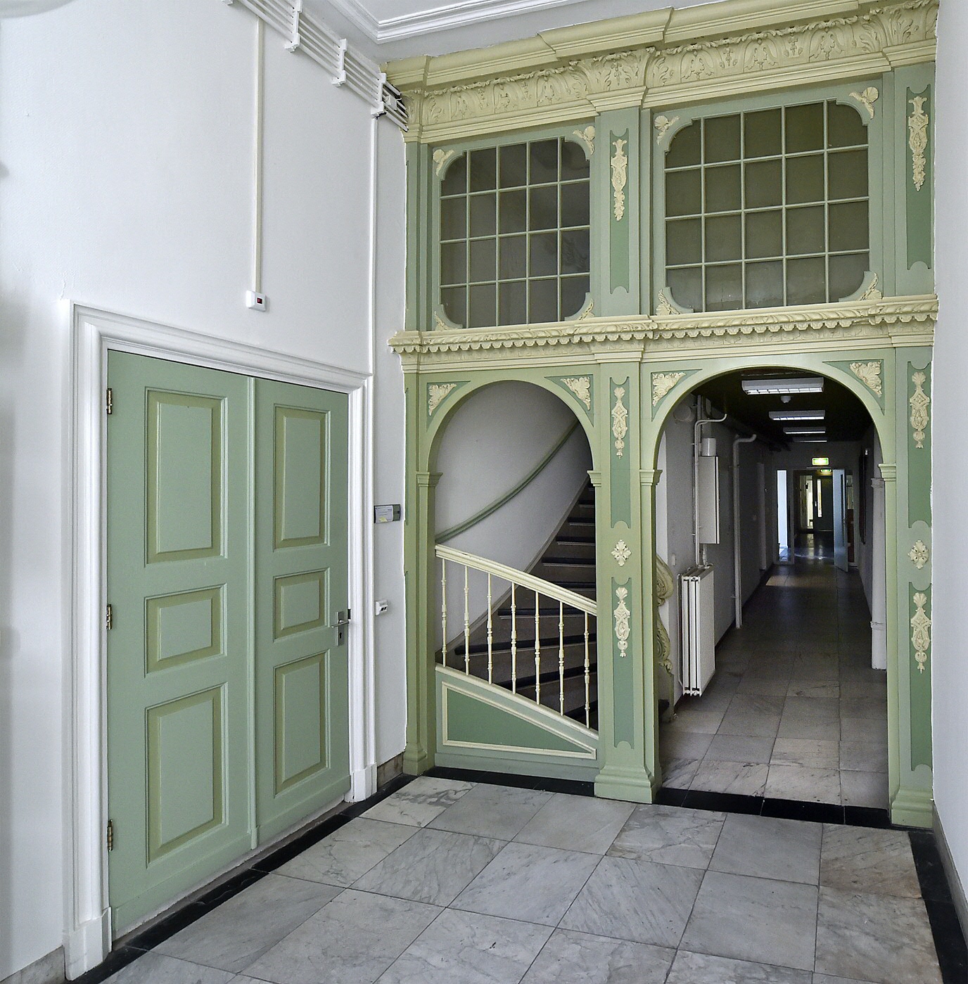Inside the building of the UG Archaeology Institute. The entrance to this old villa has a marble floor. The area between the entrance hall, staircase and corridor is also remarkable, because of the wooden partition decorated with beautiful carvings.