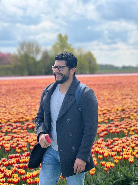 A laughing young man walking in the field of tulips