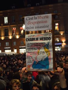 Sign in front of the Capitole at the rally in support of the victims of the 2015 Charlie Hebdo shooting (“That’s the Freedom of speech that has been murdered”). Below, the issue published that very morning. 7 January 2015. Source: Gyrostat (Wikimedia, CC-BY-SA 4.0)