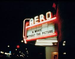 An old fashioned movie theatre sign that reads "A movie without the picture", topped with neon letters spelling "AERO".