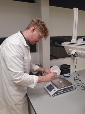 Freese weighs chemicals in his laboratory using a more sustainable glass weighing instrument