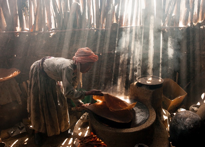 Ethiopian woman cooking on open fire ©Lynn Johnson