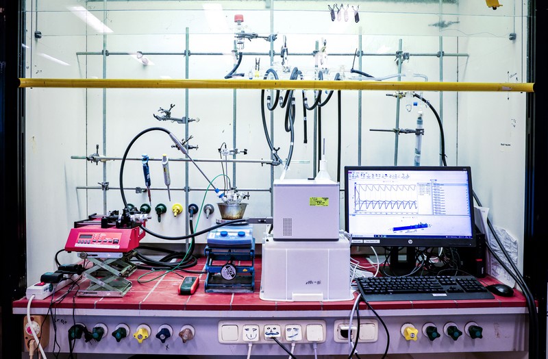 The set-up of the experiment, with the flow reactor in the center and a screen showing the oscillations in real time on the right. | Photo Leoni von Ristok / Science LinX