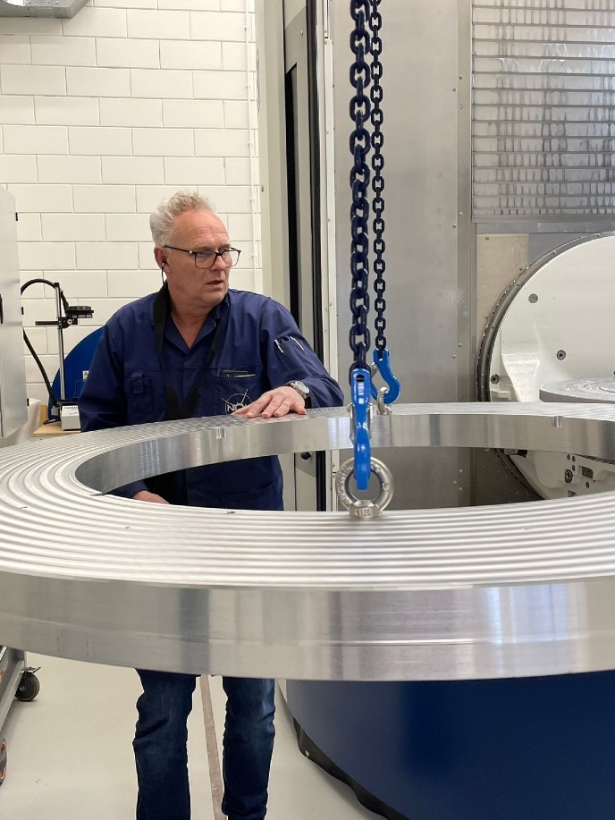 Operator Menno Schuil hijst een blok aluminium in de freesmachine Operator Menno Schuil hoists an aluminium block into the milling machine 