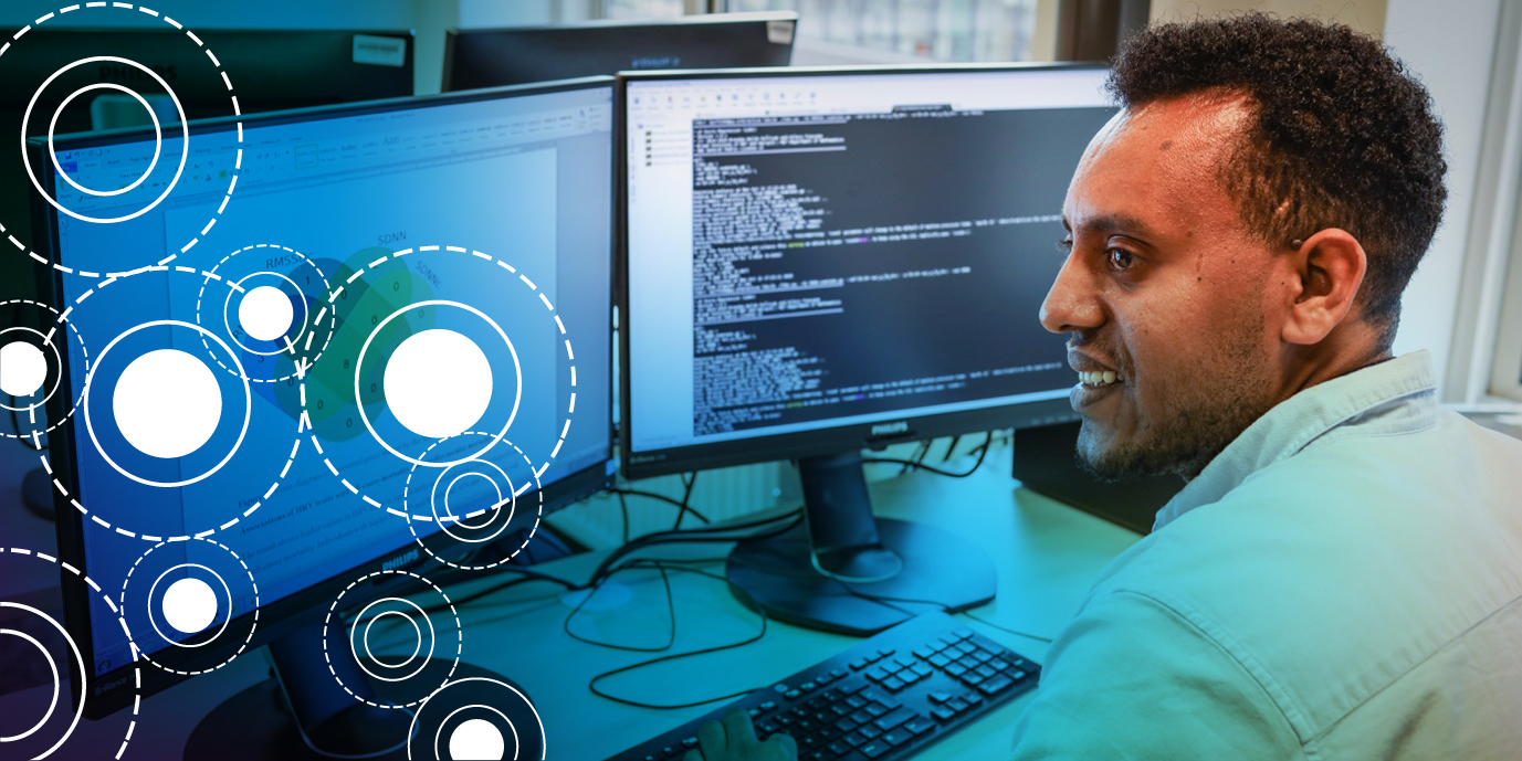 Foto van een persoon voor twee computerschermen